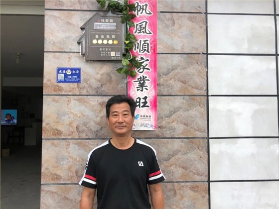 ▲钱爱新和家门口的&ldquo;小桔灯&rdquo;